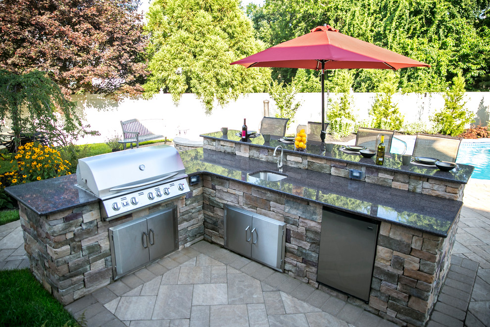 Mid-sized elegant backyard concrete paver patio kitchen photo in New York