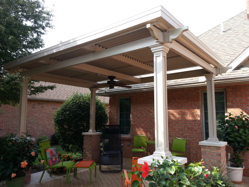 Immagine di un patio o portico eclettico di medie dimensioni e in cortile con un gazebo o capanno e pavimentazioni in mattoni
