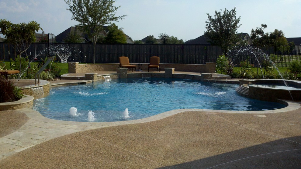 Пример оригинального дизайна: бассейн среднего размера, произвольной формы на заднем дворе в классическом стиле с покрытием из бетонных плит и джакузи