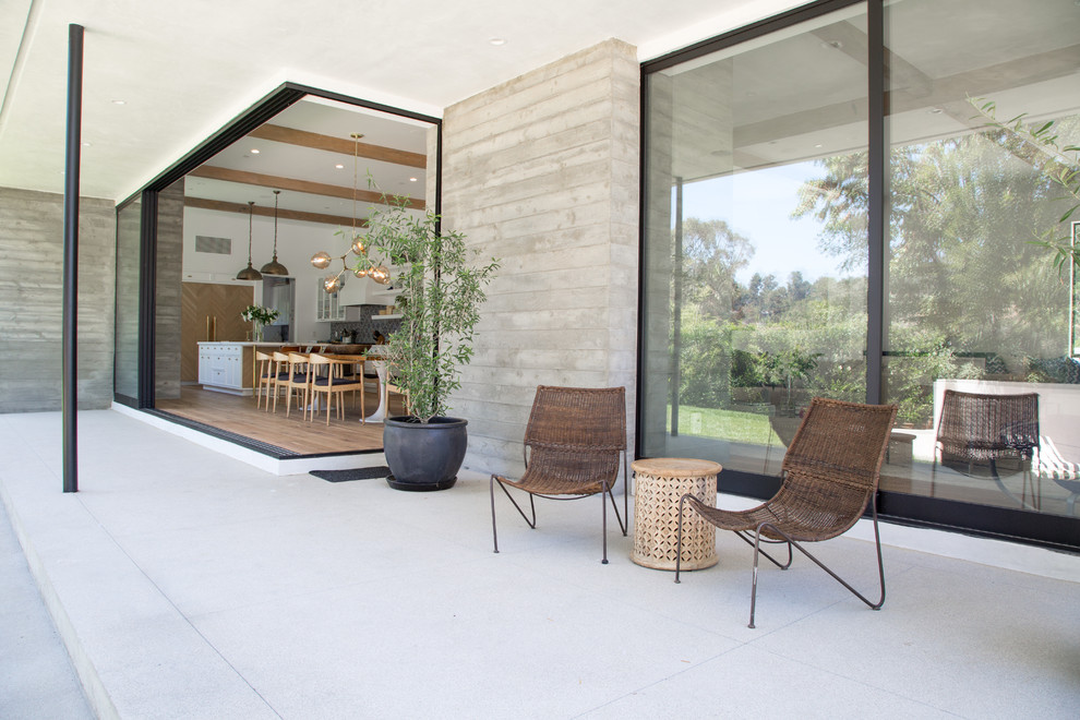 Пример оригинального дизайна: двор среднего размера на заднем дворе в стиле неоклассика (современная классика) с покрытием из бетонных плит и навесом