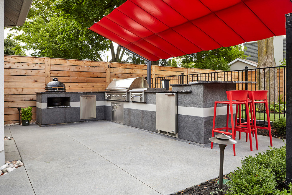 Foto di un patio o portico minimalista dietro casa con pavimentazioni in cemento e un gazebo o capanno