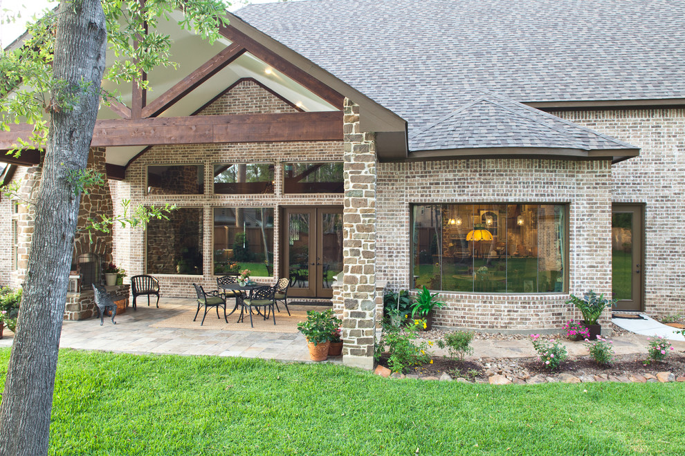 Imagen de patio clásico de tamaño medio en patio trasero y anexo de casas con brasero y adoquines de piedra natural