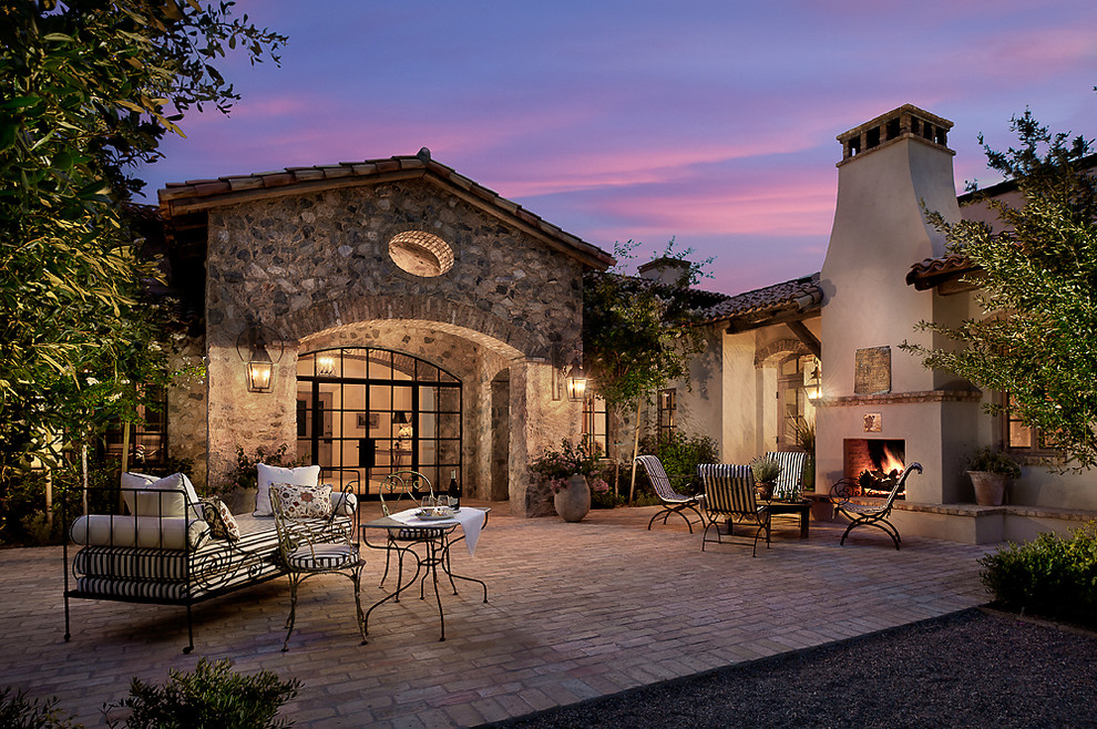 Design ideas for a patio in Phoenix with brick paving and a fire feature.