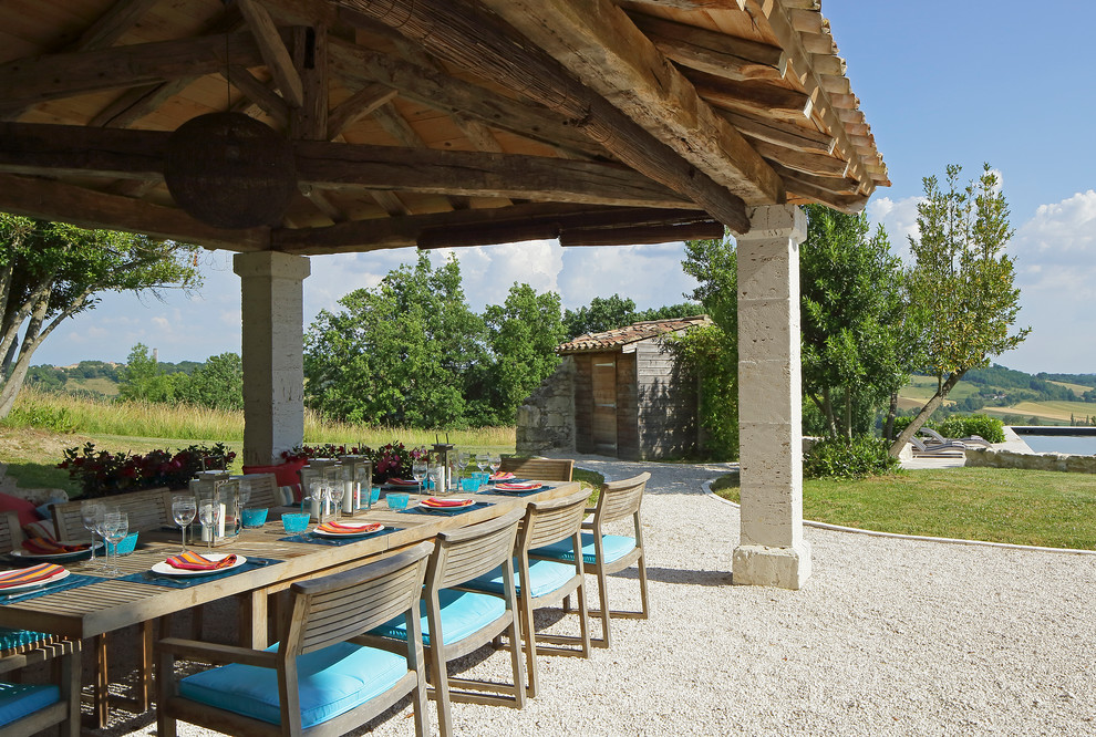 Photo of a large back patio in London with gravel and a gazebo.