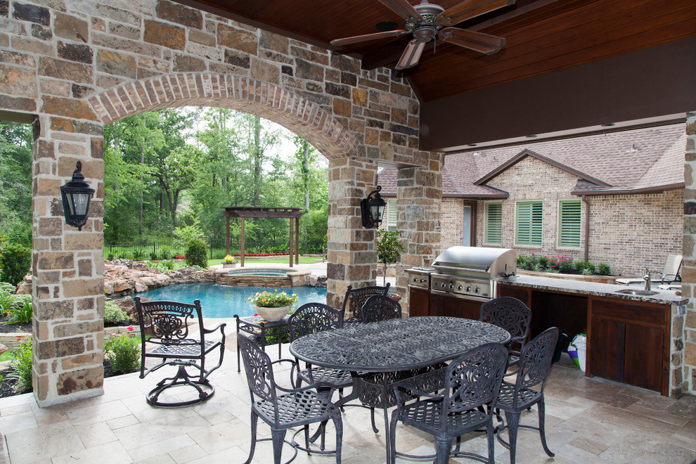 Esempio di un grande patio o portico american style dietro casa con pavimentazioni in pietra naturale e un tetto a sbalzo
