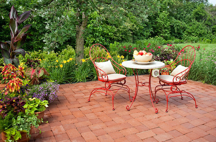 Inspiration for a small traditional back patio in Chicago with a potted garden and brick paving.