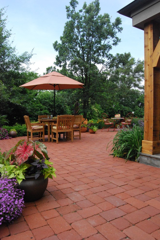 Patio - large traditional backyard brick patio idea in Chicago with a roof extension