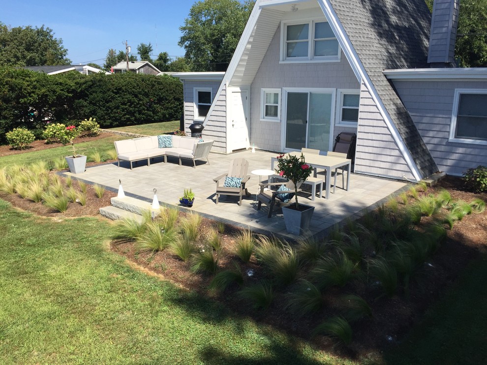 Diseño de patio costero de tamaño medio en patio trasero con adoquines de hormigón