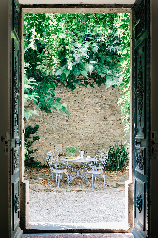 На фото: большой двор на внутреннем дворе в средиземноморском стиле без защиты от солнца с