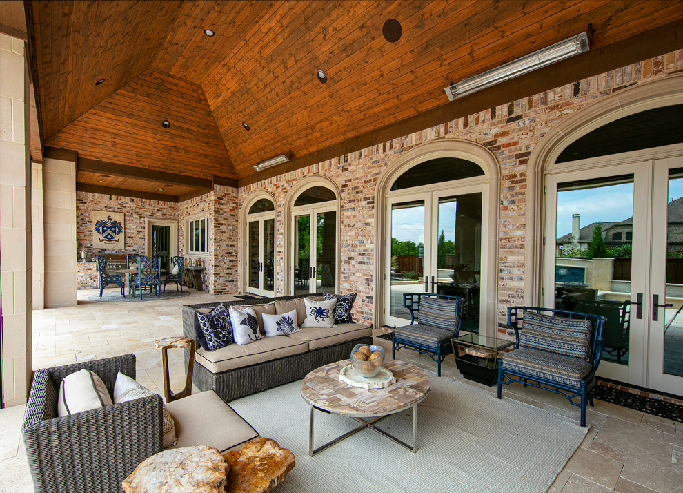This is an example of a large classic back patio in Dallas with an outdoor kitchen and a roof extension.