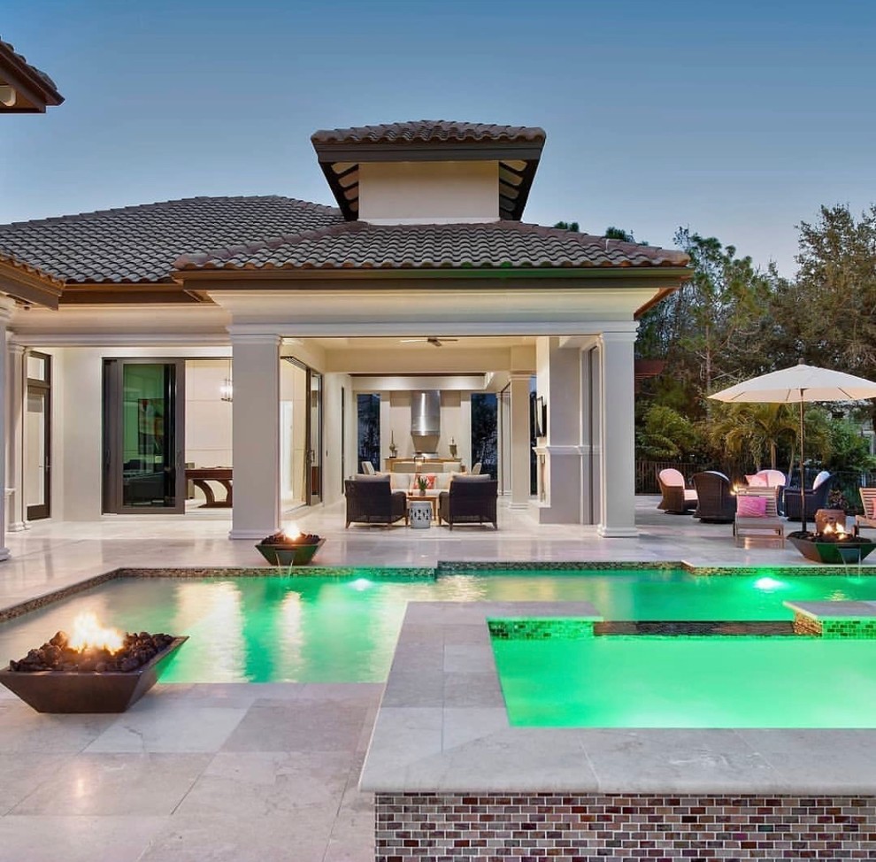 Photo of an expansive contemporary back patio in Miami with a fire feature, natural stone paving and a gazebo.