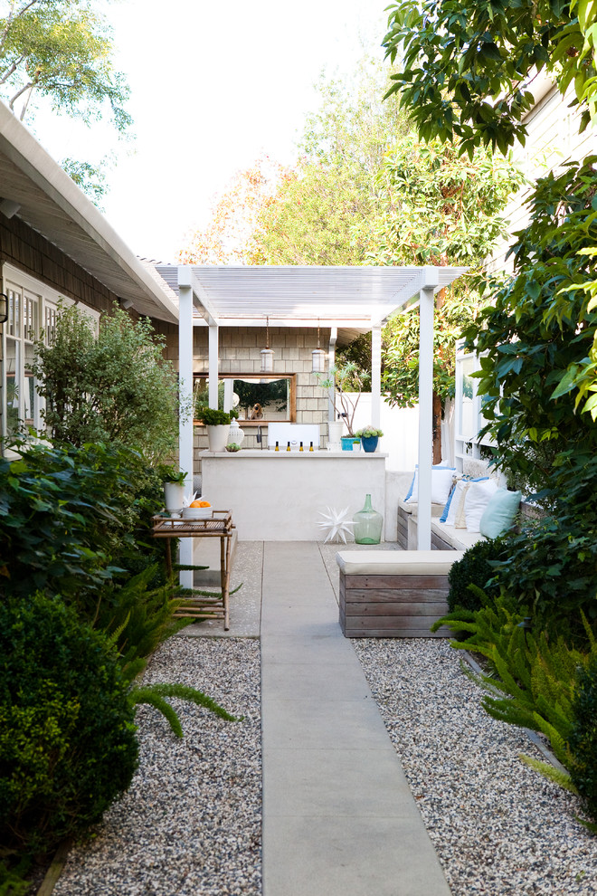 Elegant patio kitchen photo in Los Angeles with a pergola