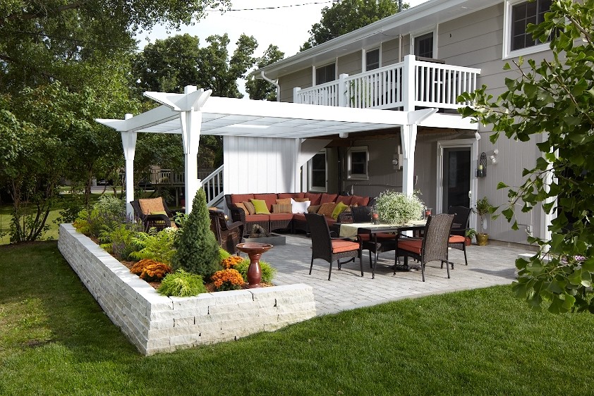 Réalisation d'une terrasse arrière tradition de taille moyenne avec un foyer extérieur, des pavés en brique et une extension de toiture.