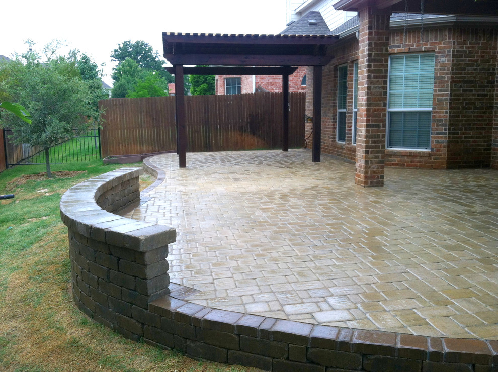 Example of a large classic backyard brick patio design in Dallas with a pergola