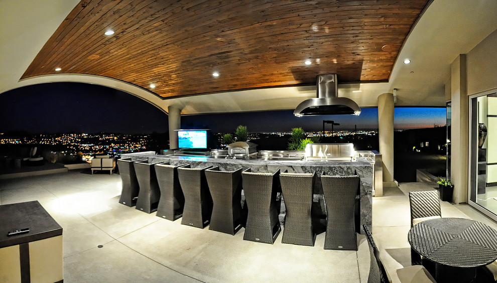 Idées déco pour une grande terrasse arrière moderne avec une cuisine d'été, une dalle de béton et une extension de toiture.