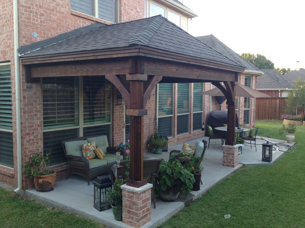 Small traditional back patio in Dallas with concrete slabs and a roof extension.