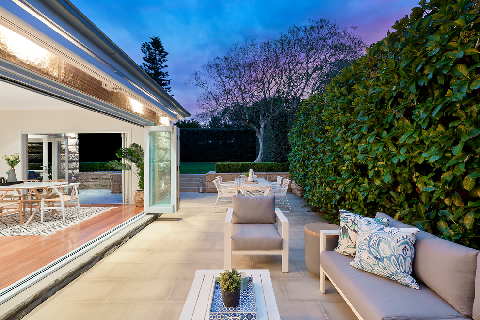 Cette image montre une grande terrasse minimaliste avec une cour et des pavés en pierre naturelle.