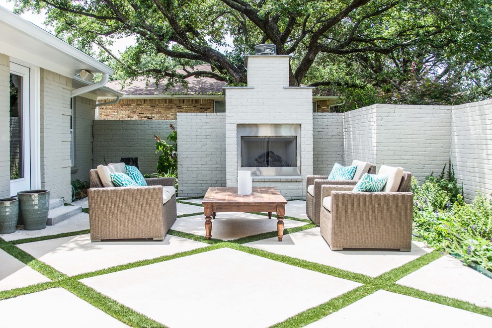 Photo of a classic patio in Dallas with concrete slabs, no cover and a fireplace.