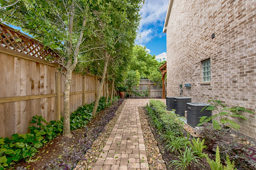 Imagen de patio clásico de tamaño medio en patio trasero con jardín vertical, adoquines de ladrillo y pérgola