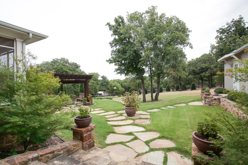 Cette photo montre une grande terrasse arrière nature avec une cuisine d'été, des pavés en pierre naturelle et aucune couverture.