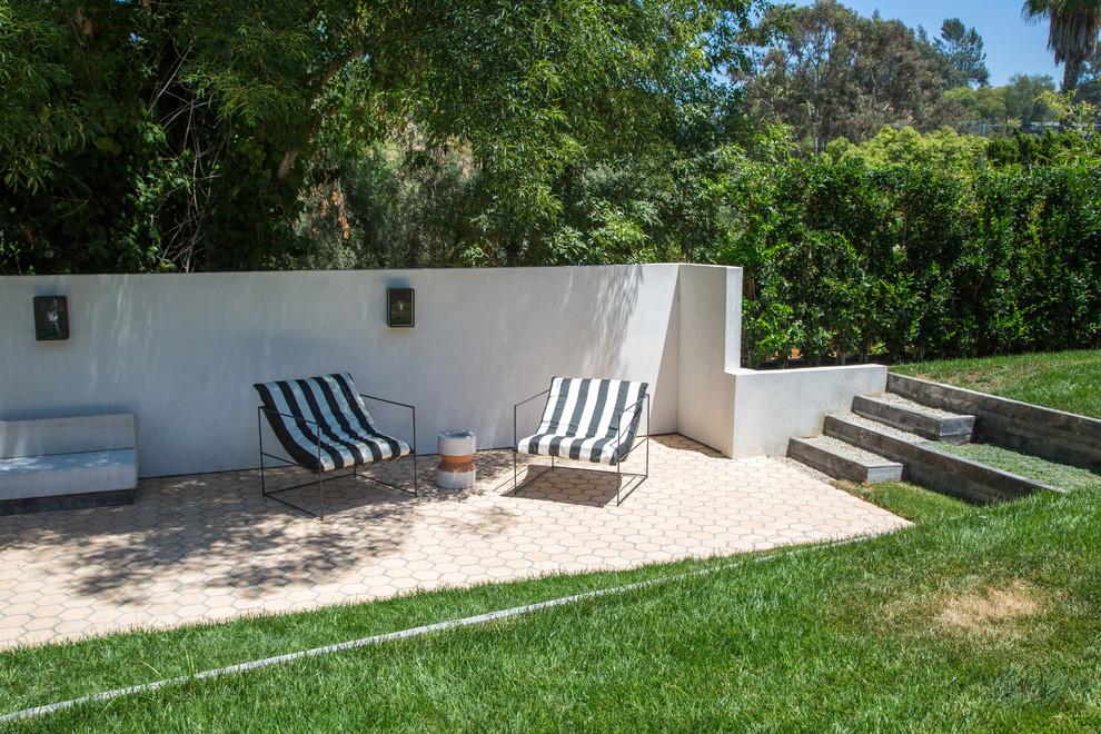 Photo of a medium sized classic back patio in Los Angeles with concrete slabs and a roof extension.