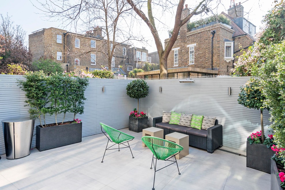 Small contemporary back patio in London with a potted garden.