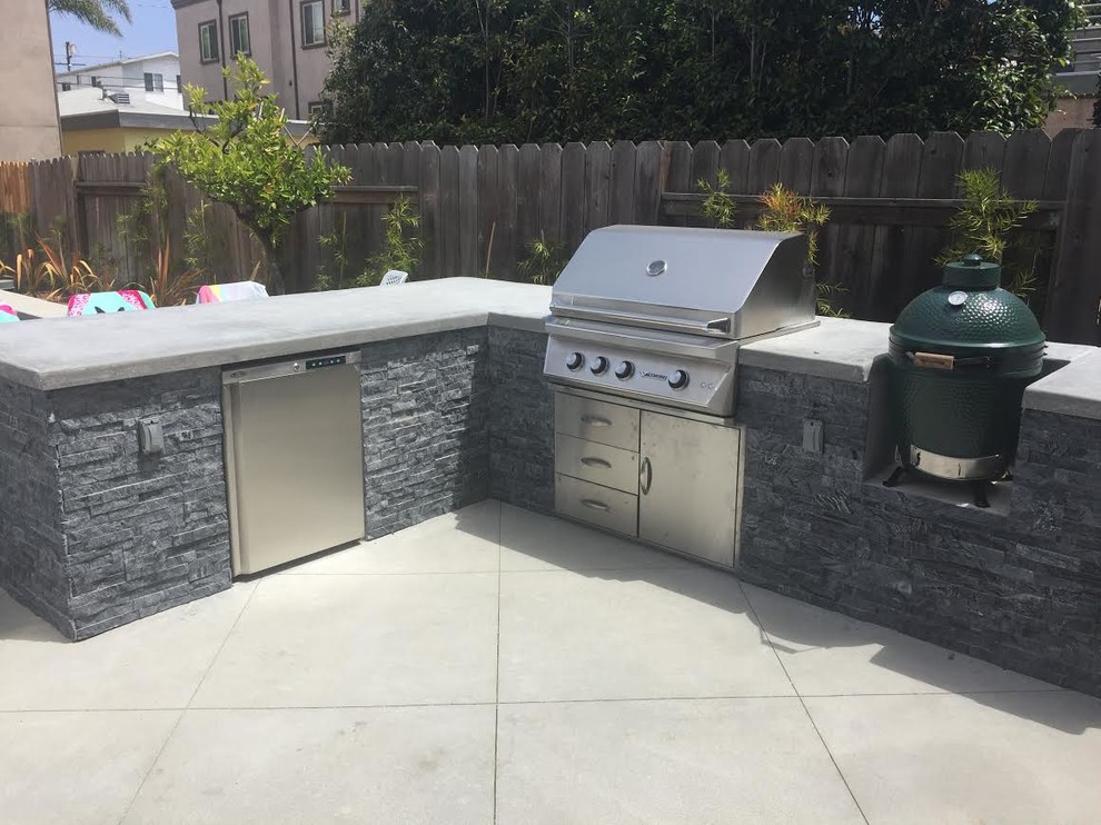 Cette photo montre une terrasse arrière tendance de taille moyenne avec une cuisine d'été, une dalle de béton et aucune couverture.
