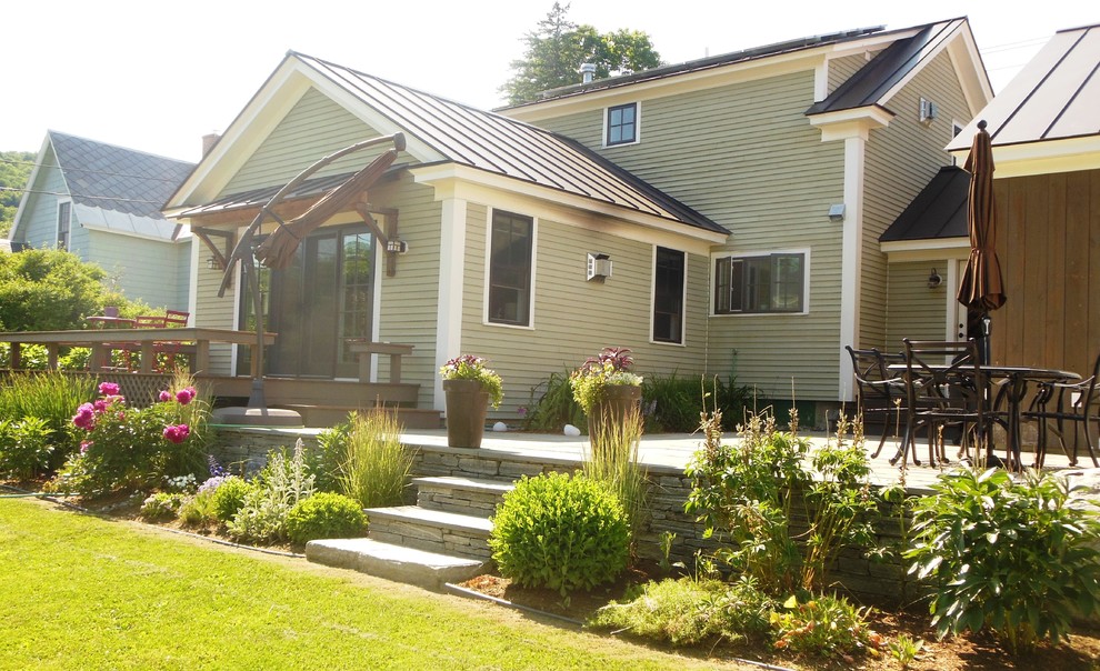 Foto di un patio o portico chic di medie dimensioni e dietro casa con pavimentazioni in pietra naturale e un tetto a sbalzo