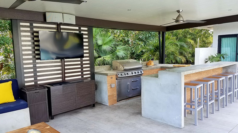 Example of a large transitional backyard concrete patio kitchen design in Miami with a pergola