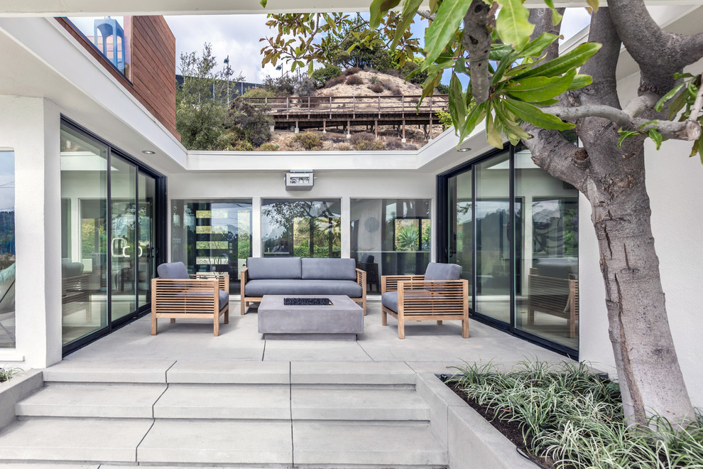 Mittelgroßer, Unbedeckter Moderner Patio hinter dem Haus mit Feuerstelle und Betonplatten in Los Angeles