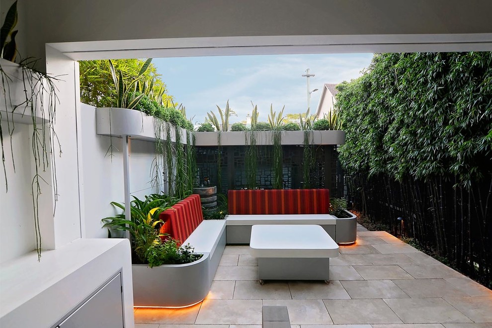 Small modern back patio in Sydney with tiled flooring and no cover.