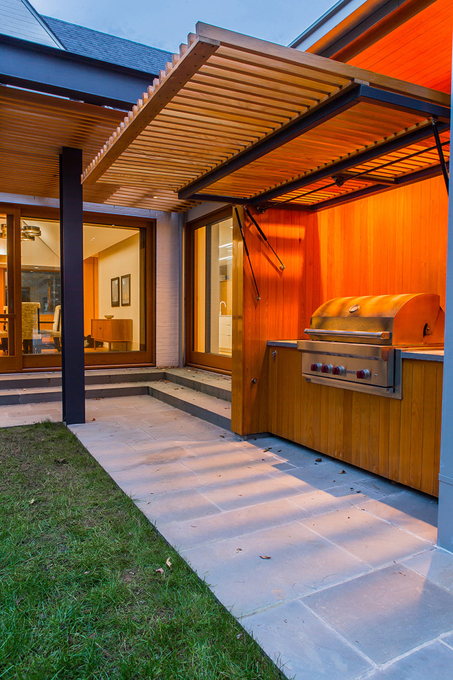 Foto di un patio o portico design di medie dimensioni e dietro casa con pavimentazioni in pietra naturale e un tetto a sbalzo