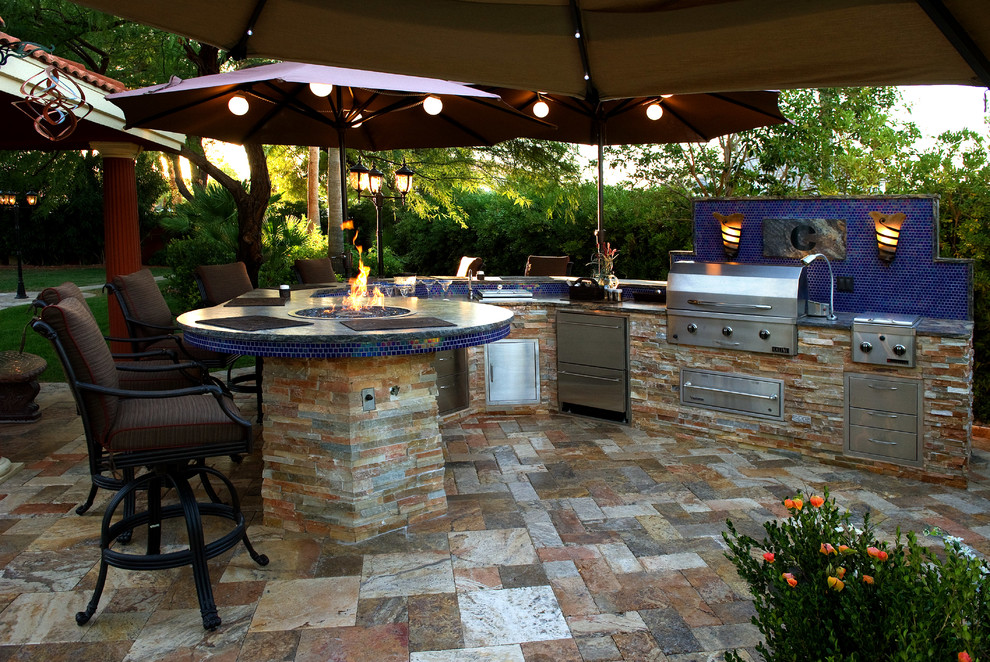 Design ideas for an expansive modern back patio in Phoenix with an outdoor kitchen, natural stone paving and a gazebo.