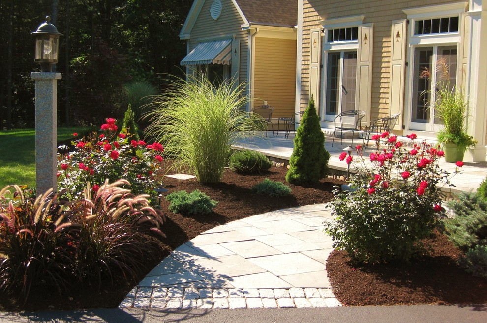 Example of a small beach style front yard stone patio design in Portland Maine with no cover