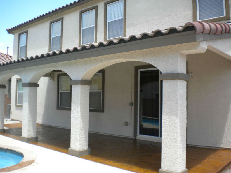Immagine di un patio o portico stile americano di medie dimensioni e dietro casa con pavimentazioni in pietra naturale e un parasole