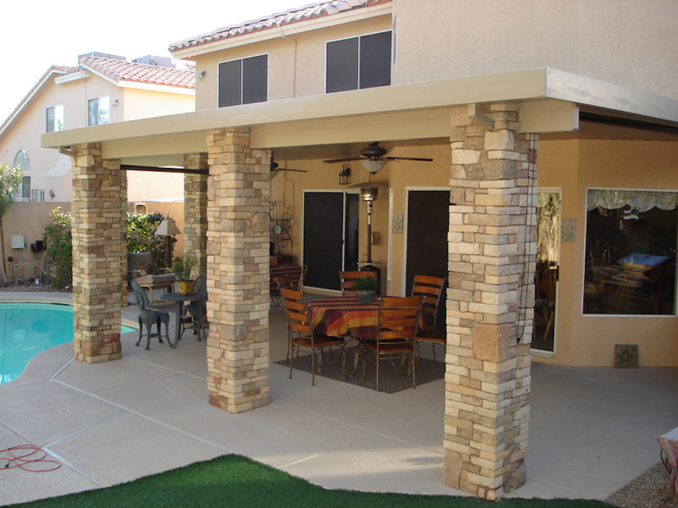 Classic back patio in Las Vegas with a roof extension and concrete slabs.