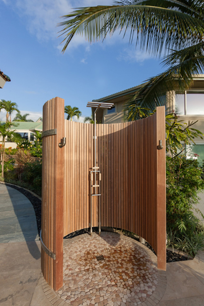 Modelo de patio tropical en patio trasero con ducha exterior y adoquines de piedra natural