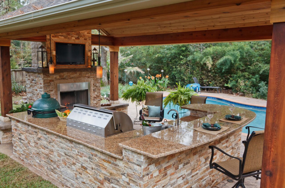 Photo of a large classic back patio in Houston with an outdoor kitchen, gravel and no cover.