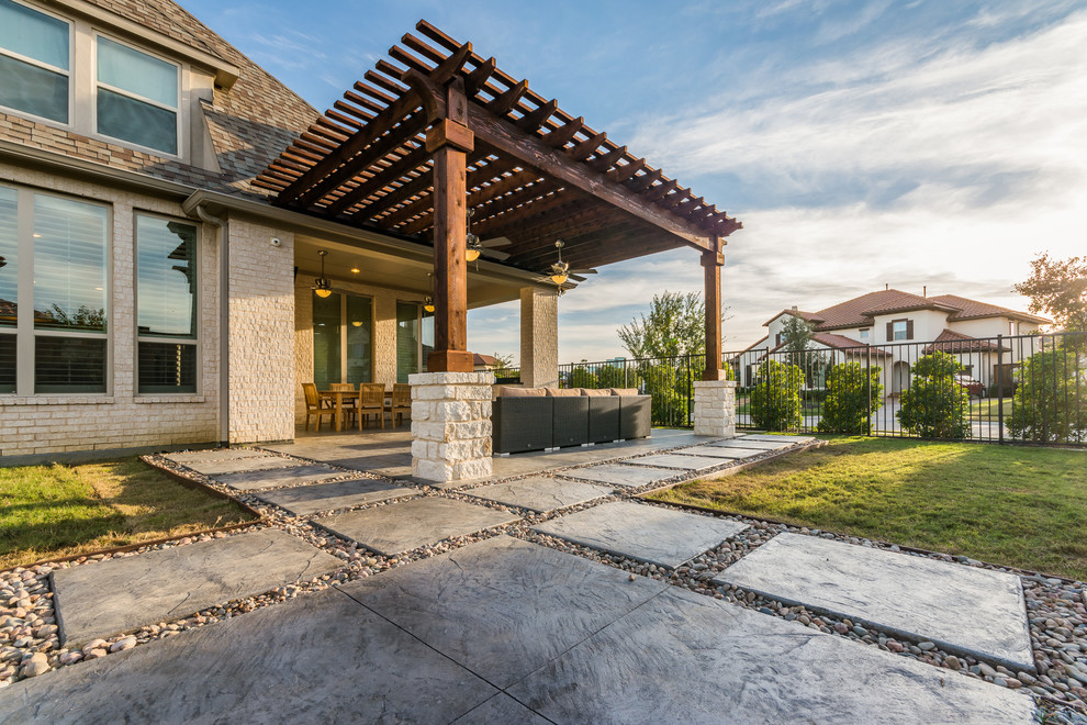 Immagine di un grande patio o portico chic dietro casa con cemento stampato e una pergola