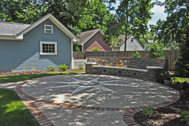 Imagen de patio clásico de tamaño medio sin cubierta en patio trasero con losas de hormigón