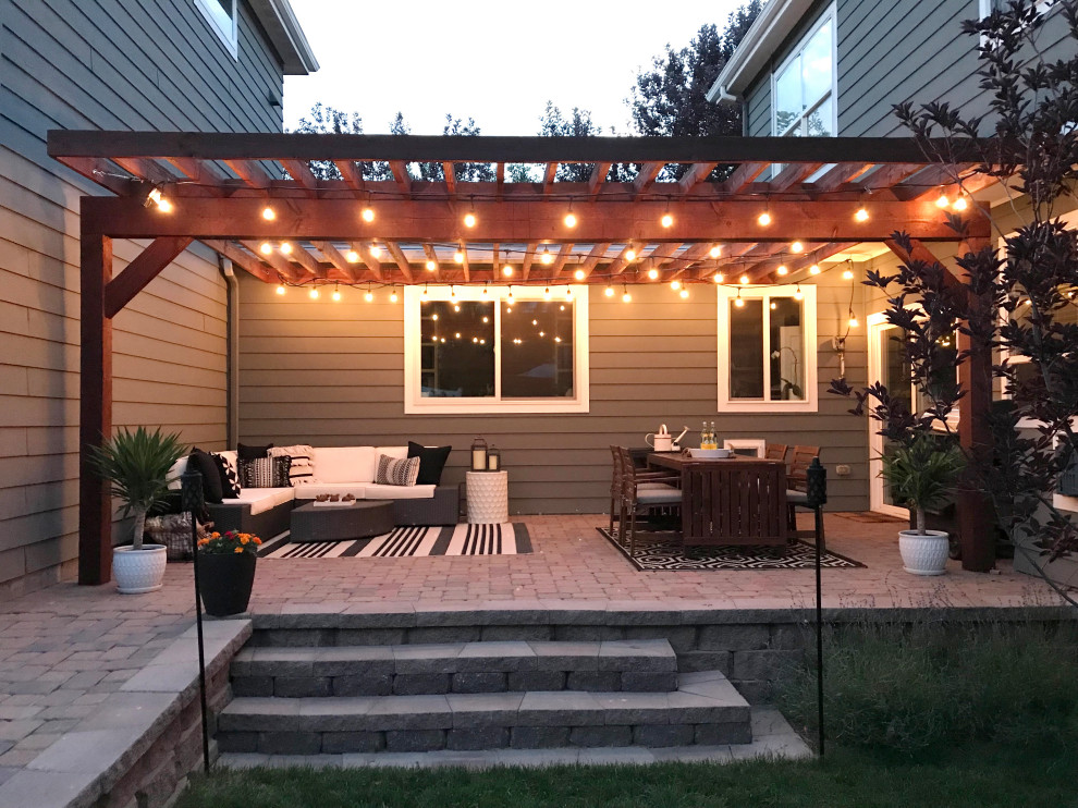 Immagine di un patio o portico moderno di medie dimensioni e dietro casa con pavimentazioni in mattoni e una pergola