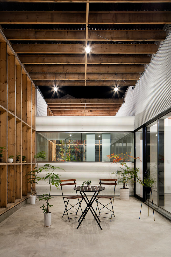 Esempio di un patio o portico industriale in cortile con pavimentazioni in cemento e una pergola