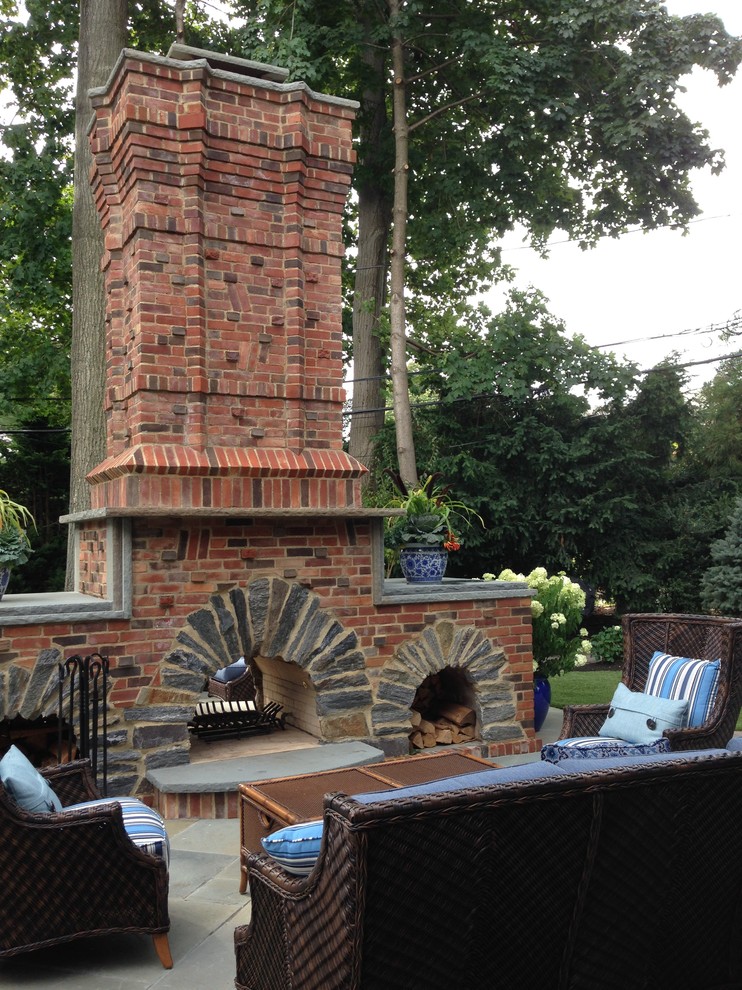 Imagen de patio clásico de tamaño medio en patio trasero con brasero y adoquines de ladrillo