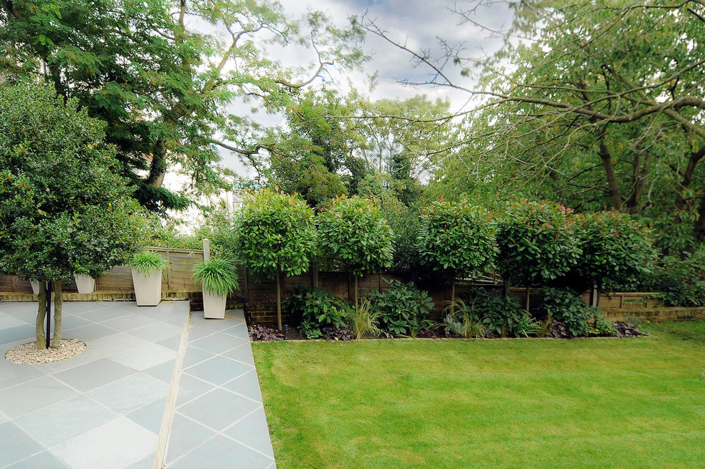 Contemporary patio in London with natural stone paving.