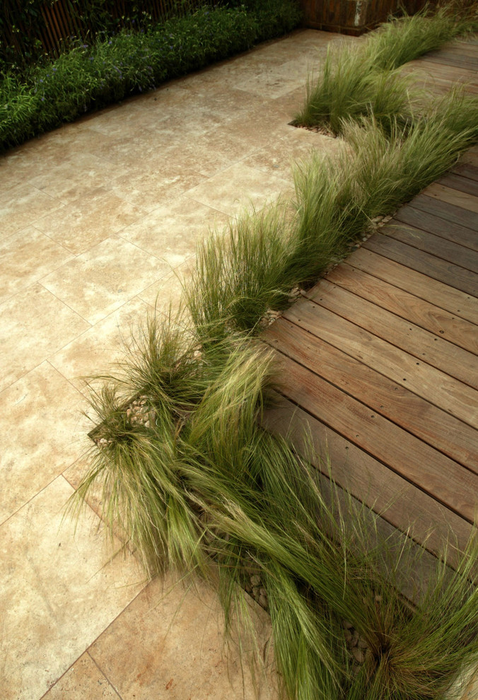 Example of a trendy backyard stone patio design in London
