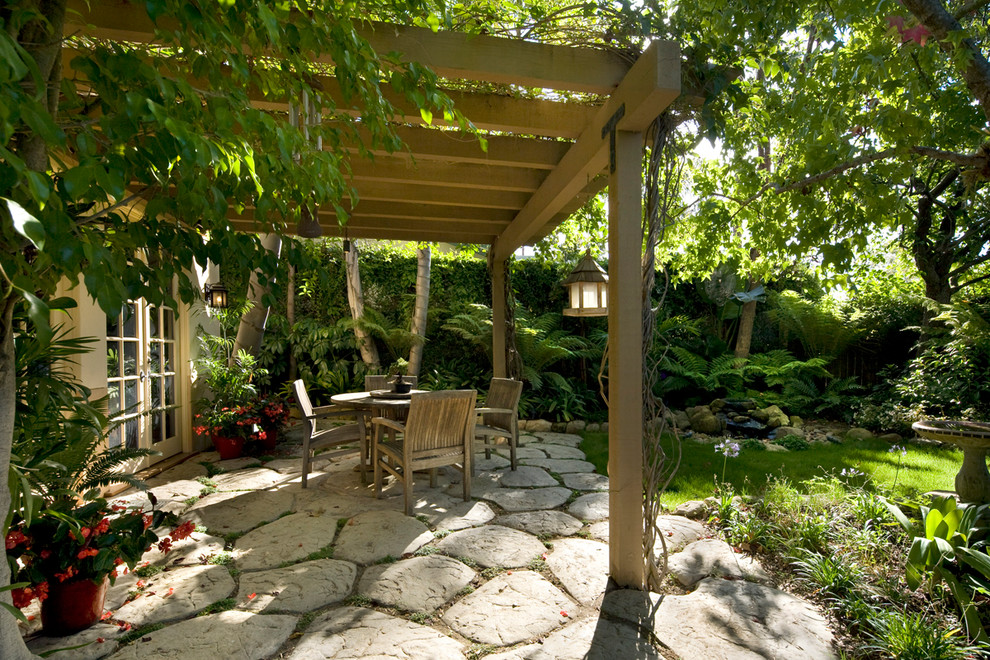 На фото: пергола во дворе частного дома на заднем дворе в стиле фьюжн с фонтаном и мощением тротуарной плиткой с