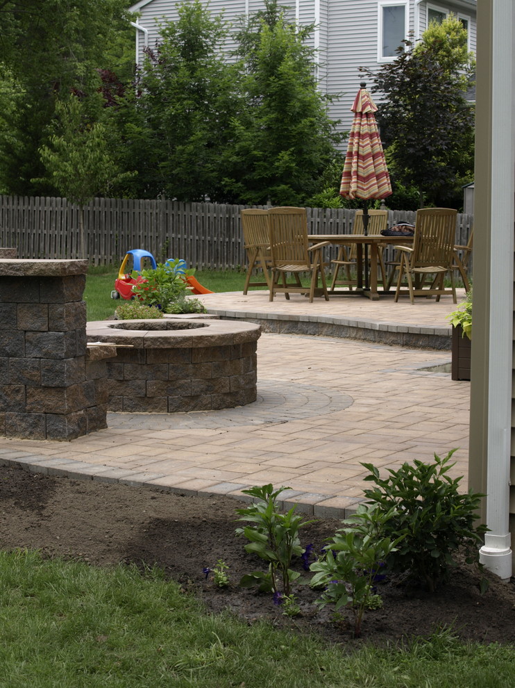 Inspiration for a large timeless backyard concrete paver patio remodel in New York with a fire pit and no cover