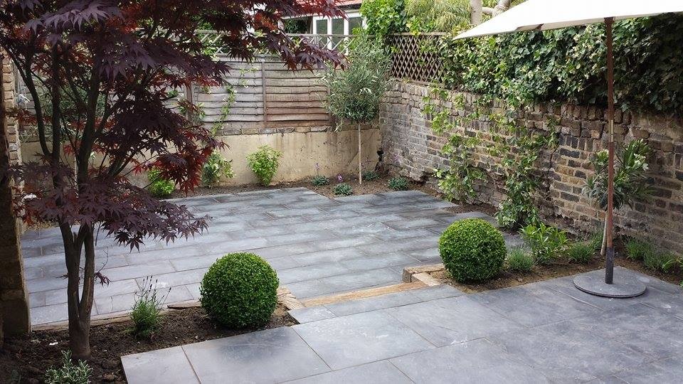 Inspiration for a small contemporary backyard stone patio remodel in London