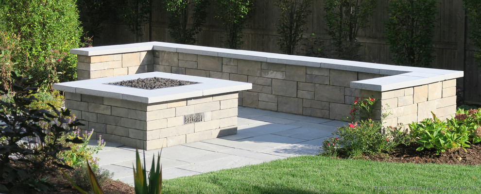 Inspiration for a traditional back patio in New York with a fire feature, concrete slabs and no cover.