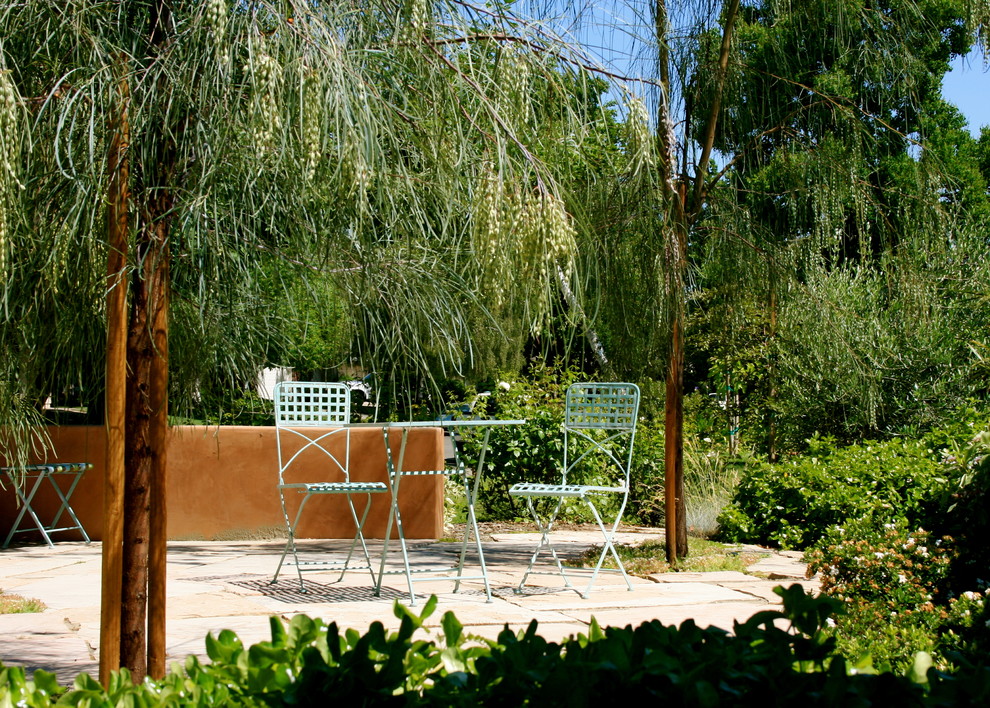 Bild på en medelhavsstil gårdsplan, med en vertikal trädgård och naturstensplattor